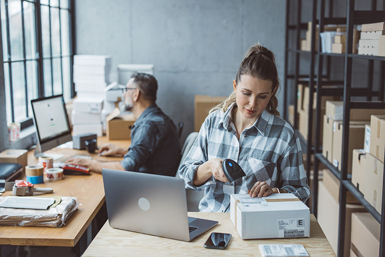 A woman and a man working at their small business packing something up