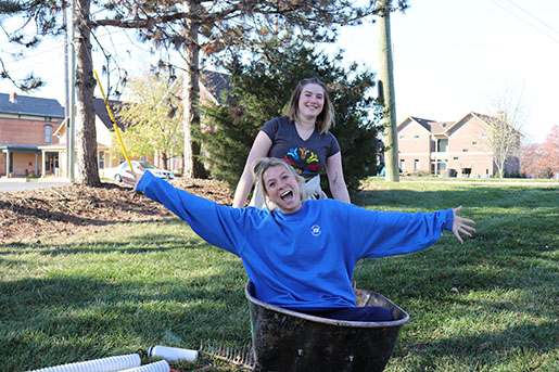 Two Indiana Farm Bureau Insurance employees smiling and having fun while planting trees with Keeping Indianapolis Beautiful (KIB)