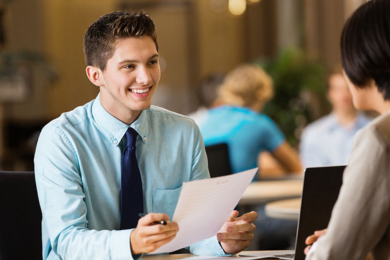 young man adult talking to recruiter with his resume